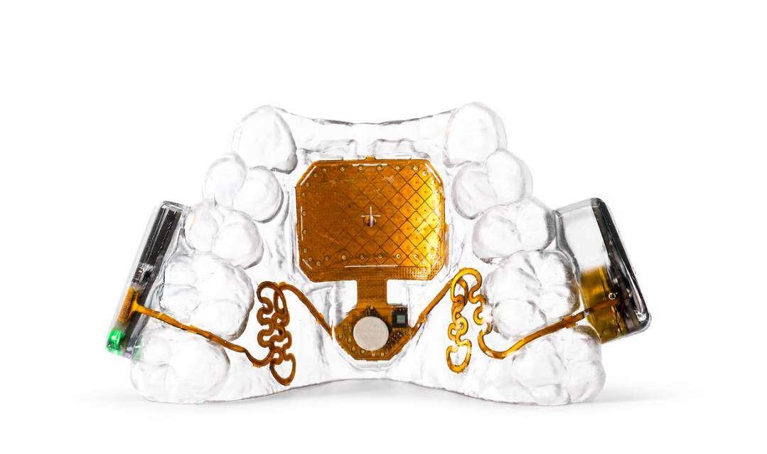 Close-up of the Augmental MouthPad, a custom-fit Bluetooth smart mouthpiece with an integrated touch sensor designed for hands-free computer and smartphone control using tongue movements.